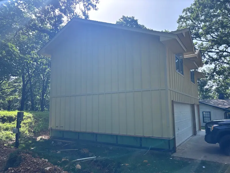 Garage with new board-and-batten siding primed, before the final finish
